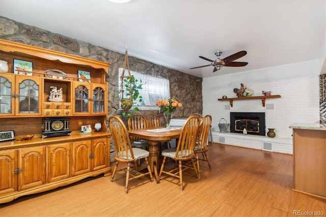 1922 Graves Ct, Northglenn, CO 80233 - dining space featuring a ceiling fan, light wood finished floors, and a glass covered fireplace