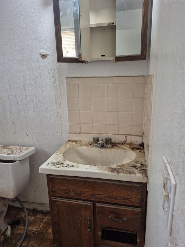 18249 E Mexico Pl, Aurora, CO 80017 - half bathroom featuring vanity, tasteful backsplash, and toilet