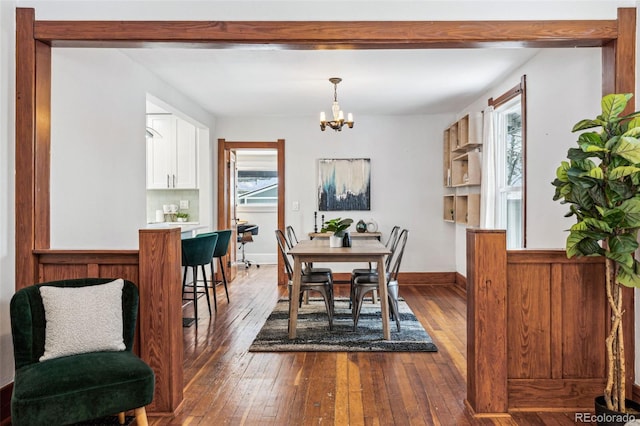 dining area with a chandelier and dark hardwood / wood-style flooring