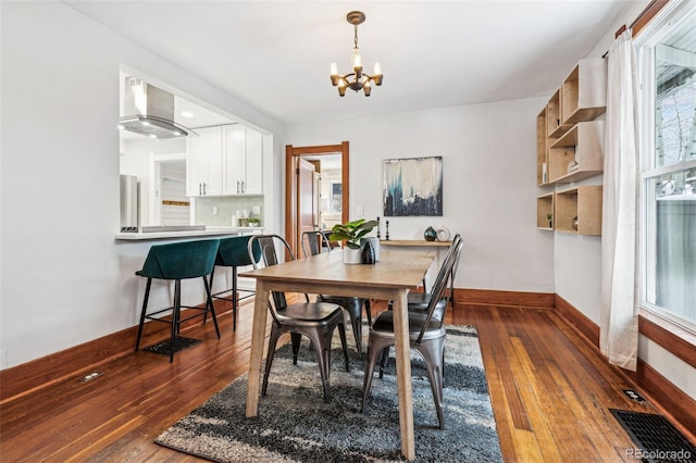 dining room featuring dark hardwood / wood-style flooring, a wealth of natural light, and an inviting chandelier