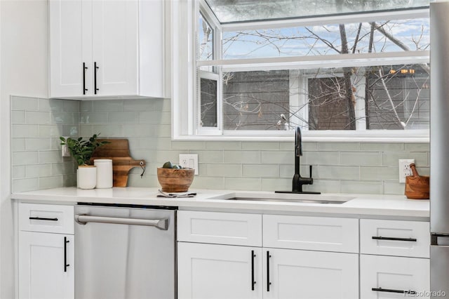 bar with tasteful backsplash, white cabinetry, dishwasher, and sink