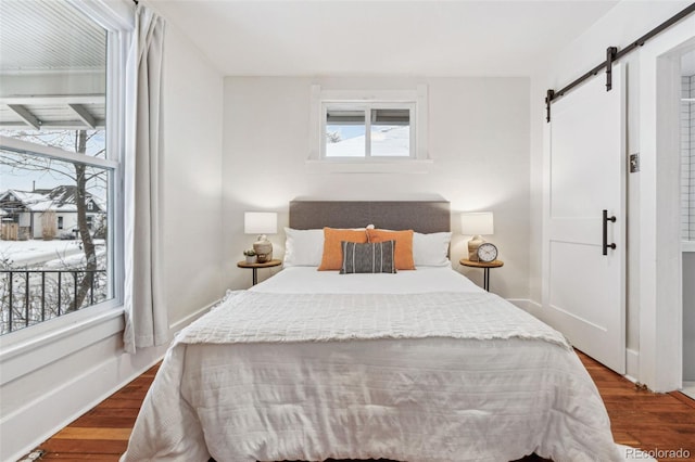 bedroom featuring a barn door and hardwood / wood-style floors