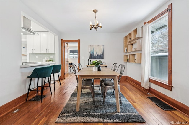 dining room with a notable chandelier and dark hardwood / wood-style flooring