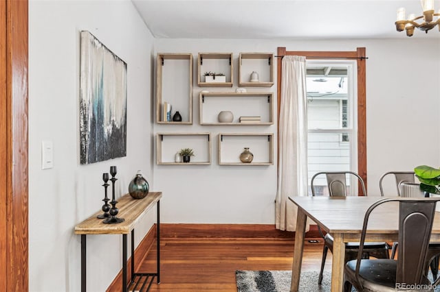 dining area featuring hardwood / wood-style flooring and a notable chandelier