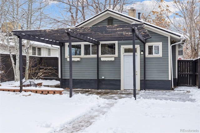 snow covered property with a pergola