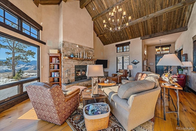 living room featuring light wood-type flooring, beamed ceiling, plenty of natural light, and high vaulted ceiling