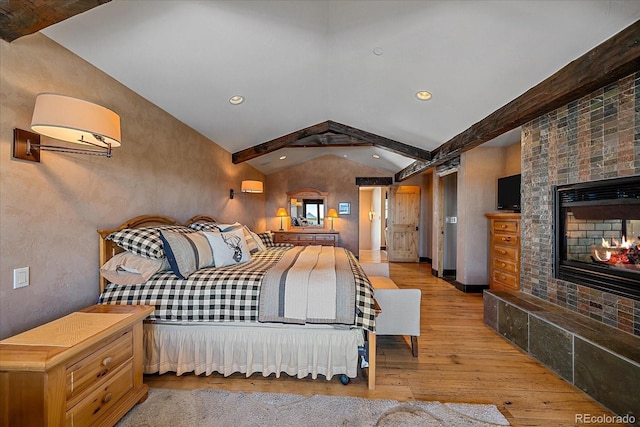 bedroom with light hardwood / wood-style floors and vaulted ceiling with beams