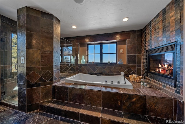 bathroom with plus walk in shower, tile walls, and a tile fireplace