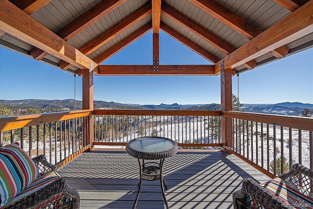 snow covered deck featuring a mountain view