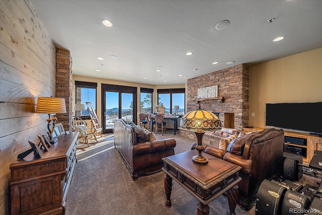 living room with a stone fireplace and carpet flooring