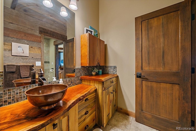 bathroom with vanity, backsplash, tile patterned floors, and wooden walls