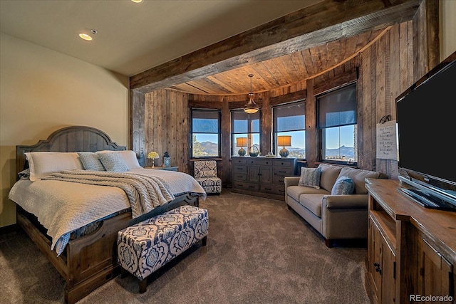 carpeted bedroom with beam ceiling and wood walls