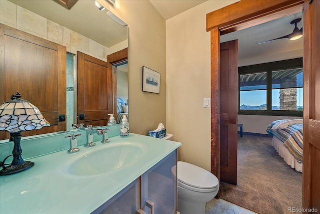 bathroom with toilet, ceiling fan, and vanity