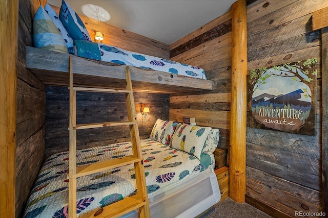 carpeted bedroom featuring wooden walls