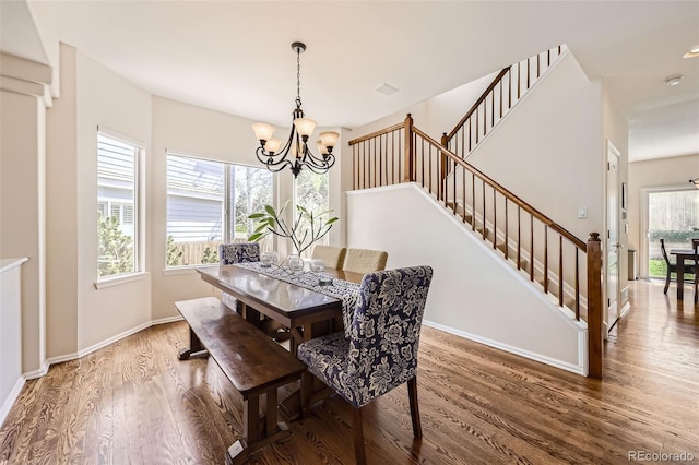 3744 Gypsum Ct, Superior, CO 80027 - dining area featuring baseboards, a notable chandelier, wood finished floors, and stairway