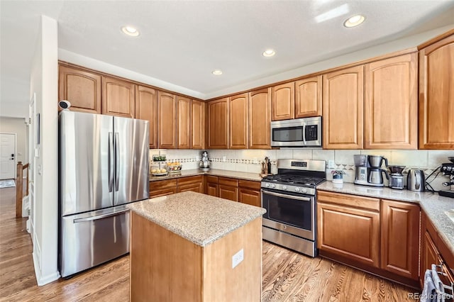3744 Gypsum Ct, Superior, CO 80027 - kitchen featuring light wood-style floors, light stone counters, a center island, and stainless steel appliances