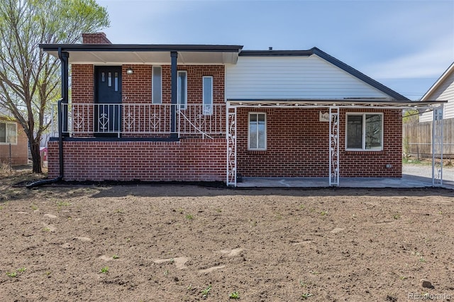 6600 E 76th Pl, Commerce City, CO 80022 - rear view of house with brick siding, a chimney, fence, and a patio area