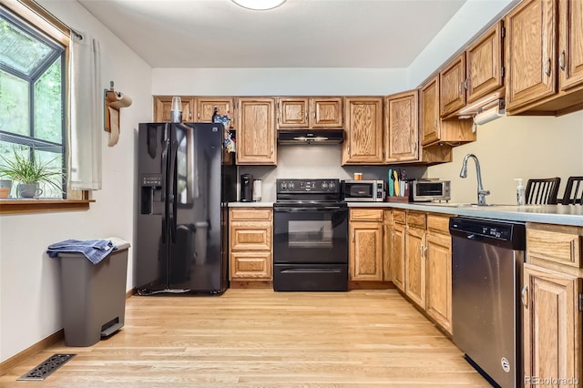 800 Illinois St Unit 1, Golden, CO 80401 - kitchen featuring black appliances, under cabinet range hood, light wood-style flooring, a sink, and light countertops