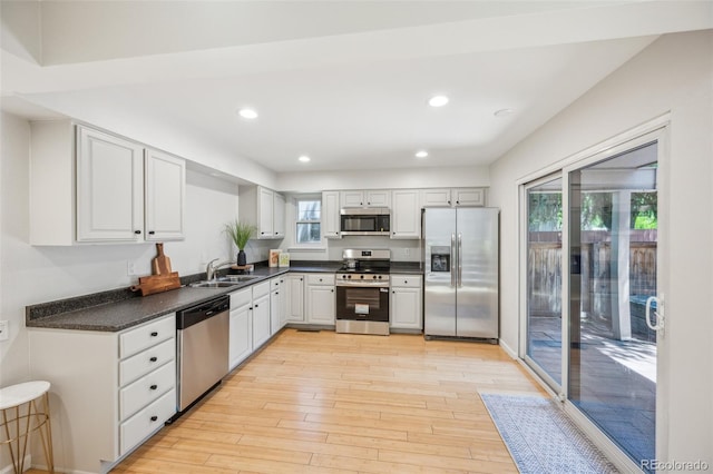 1219 S Yosemite Way Unit 63, Denver, CO 80247 - kitchen with stainless steel appliances, dark countertops, light wood finished floors, and recessed lighting