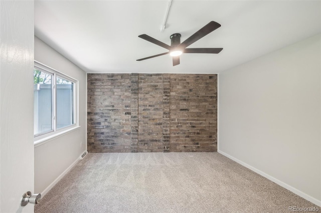 1219 S Yosemite Way Unit 63, Denver, CO 80247 - spare room featuring brick wall, a ceiling fan, carpet floors, and baseboards