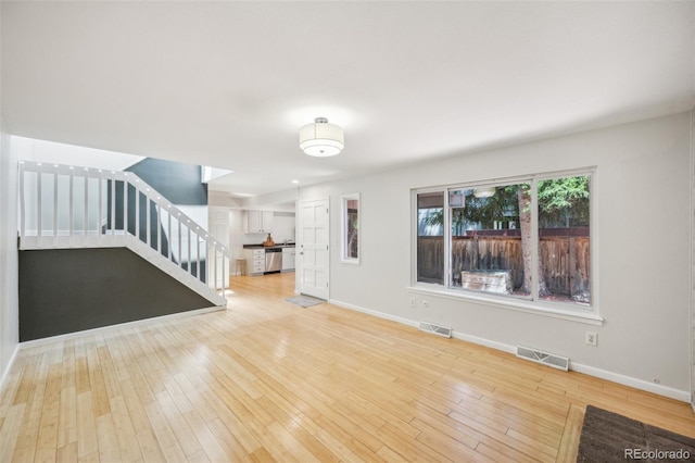 1219 S Yosemite Way Unit 63, Denver, CO 80247 - unfurnished living room with stairway, baseboards, and wood-type flooring