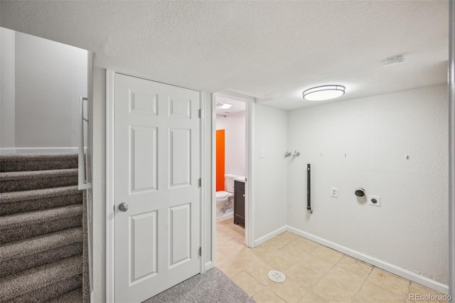 1219 S Yosemite Way Unit 63, Denver, CO 80247 - washroom with hookup for an electric dryer, a textured ceiling, baseboards, and light tile patterned floors