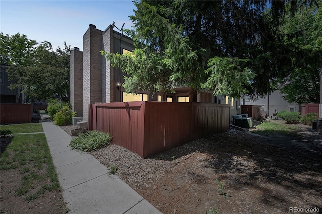 1219 S Yosemite Way Unit 63, Denver, CO 80247 - view of home's exterior with central AC unit and a chimney