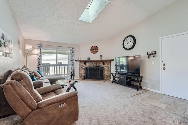 living room featuring lofted ceiling with skylight, carpet, a textured ceiling, and a fireplace