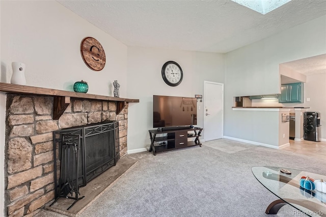 living room featuring carpet flooring, a textured ceiling, a fireplace, and a skylight