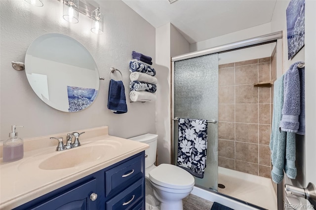 bathroom featuring toilet, vanity, and walk in shower