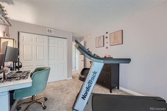 office featuring light carpet and a textured ceiling