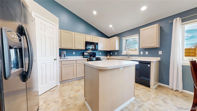 kitchen featuring light countertops, a healthy amount of sunlight, a kitchen island, a sink, and black appliances