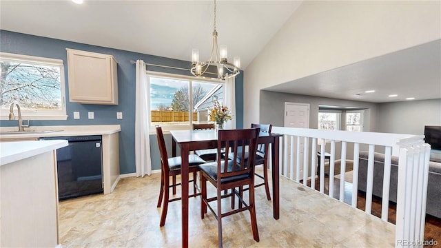 dining space featuring vaulted ceiling, plenty of natural light, baseboards, and a notable chandelier