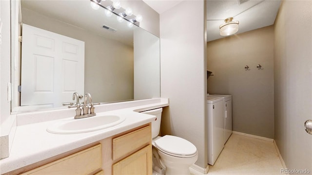 bathroom featuring toilet, vanity, visible vents, baseboards, and washer and clothes dryer