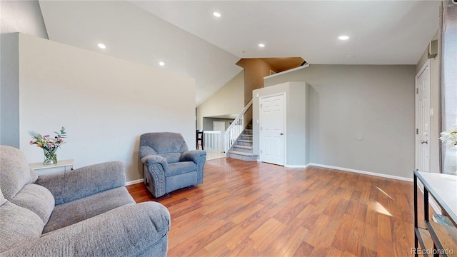 sitting room featuring lofted ceiling, recessed lighting, wood finished floors, baseboards, and stairs