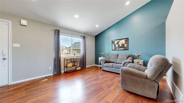 living area with baseboards, visible vents, lofted ceiling, wood finished floors, and recessed lighting