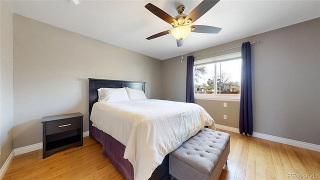 bedroom with light wood-style floors, baseboards, and a ceiling fan