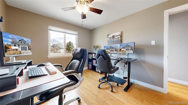 home office featuring a ceiling fan, baseboards, and wood finished floors