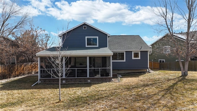 back of property featuring a yard, a shingled roof, fence, and a sunroom