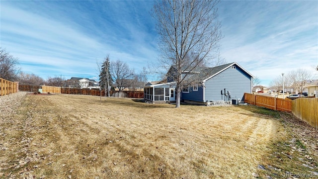 view of yard with cooling unit, a fenced backyard, and a sunroom