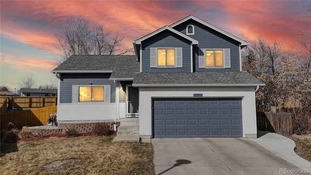 traditional-style home with an attached garage, driveway, fence, and brick siding