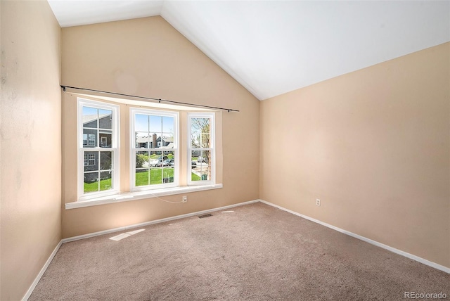 empty room with lofted ceiling, plenty of natural light, carpet, and baseboards