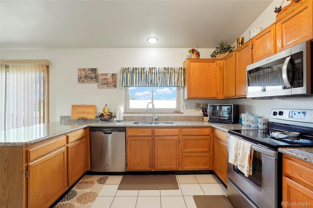 kitchen featuring kitchen peninsula, sink, light tile patterned flooring, and stainless steel appliances