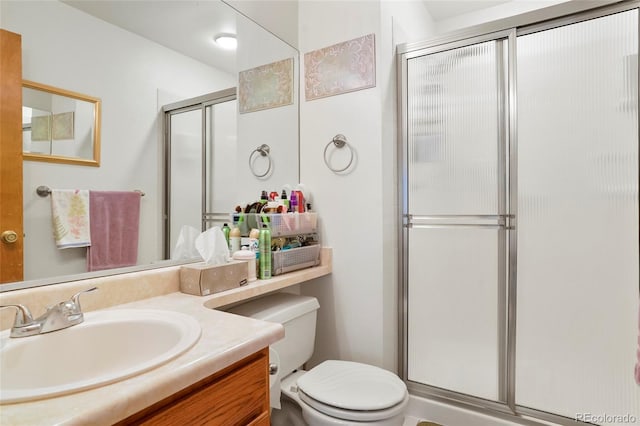 bathroom with vanity, toilet, and a shower with shower door