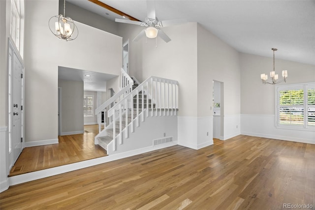 foyer featuring beam ceiling, hardwood / wood-style floors, high vaulted ceiling, and ceiling fan with notable chandelier