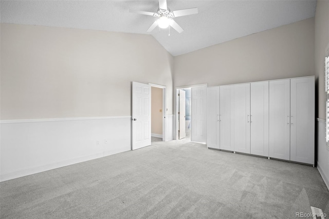 unfurnished bedroom featuring ensuite bathroom, light carpet, ceiling fan, and vaulted ceiling