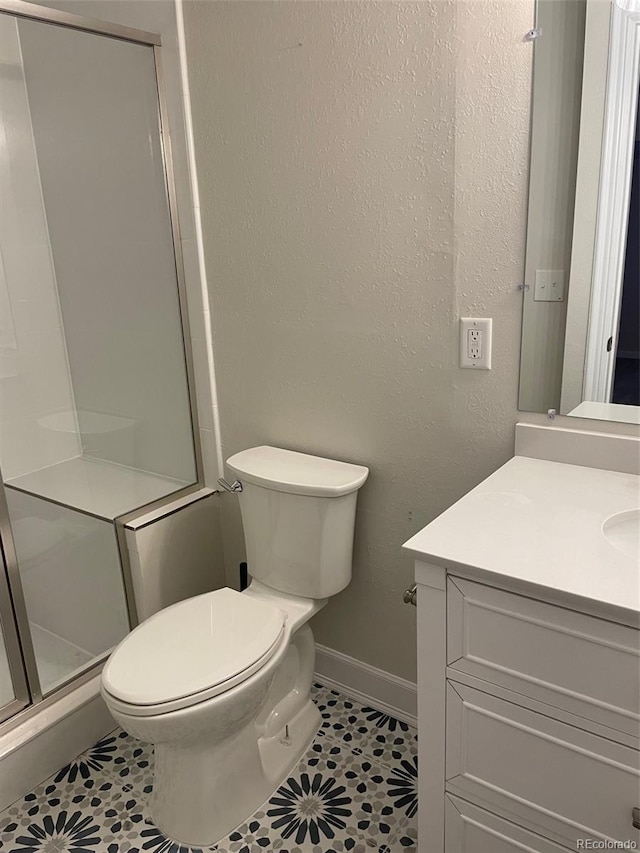 bathroom with toilet, an enclosed shower, tile patterned flooring, and vanity