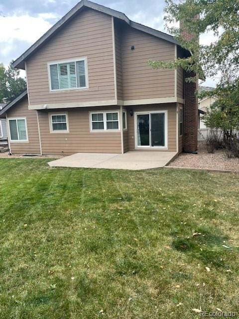 rear view of house with a patio and a lawn