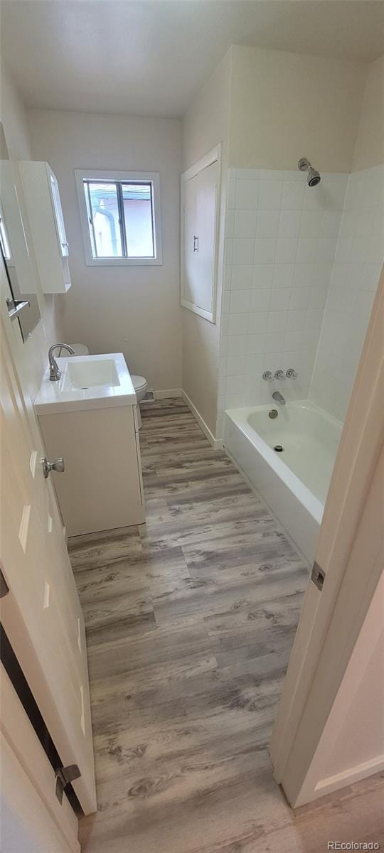 8001 Lowell Blvd, Westminster, CO 80031 - bathroom featuring baseboards, toilet, bathtub / shower combination, wood finished floors, and vanity