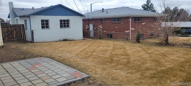 8001 Lowell Blvd, Westminster, CO 80031 - back of house featuring brick siding, a lawn, a patio, and fence